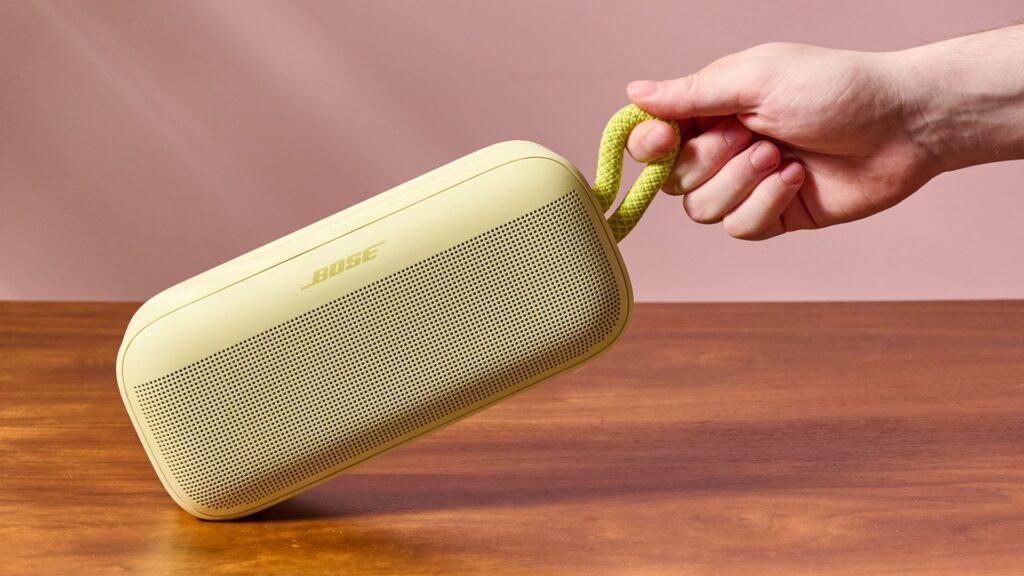 Man holding Bose SoundLink Plus by carry strap