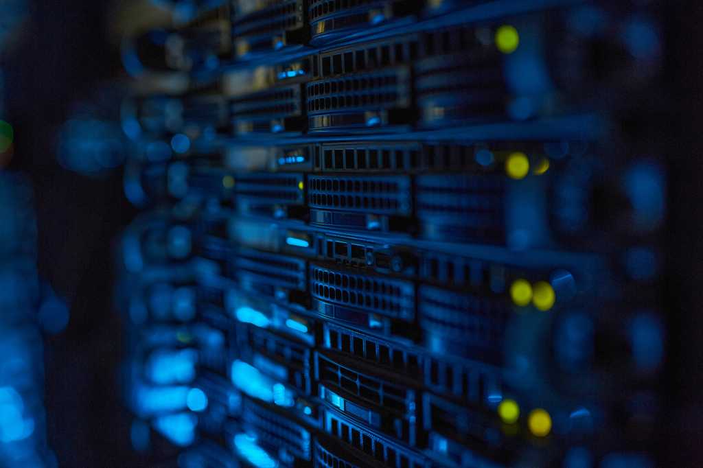 Aria Networks raises $125M, launches platform for AI factories Server racks with illuminated indicators in a dimly lit data center.