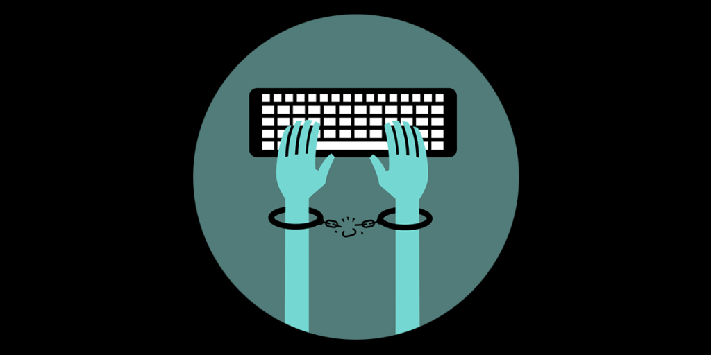 shackled hands above a keyboard