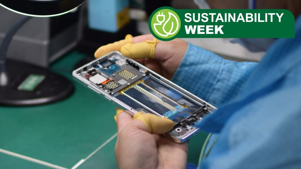 A production line worker handling a partially-built smartphone in their hand