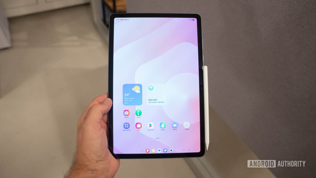 Samsung Galaxy Tab S11 in man's hand showing home screen