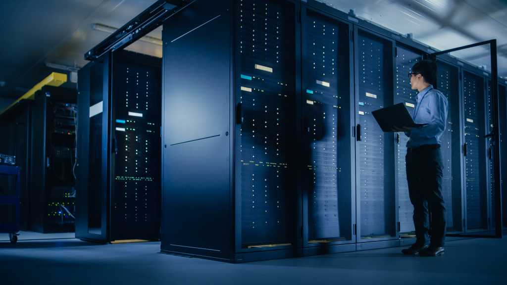 China’s LineShine dethrones El Capitan as the world’s fastest supercomputer In Data Center: Male IT Technician Running Maintenance Programme on a Laptop, Controls Operational Server Rack Optimal Functioning. Modern High-Tech Telecommunications Operational Super Computer.